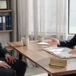 Lawyer meeting with an injured client in a private office to discuss a car accident claim and legal options.